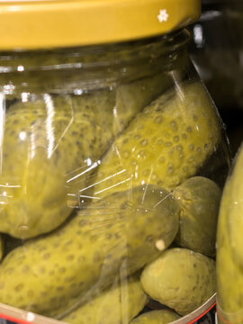 Pickled cucumbers glowing in a clear glass jar