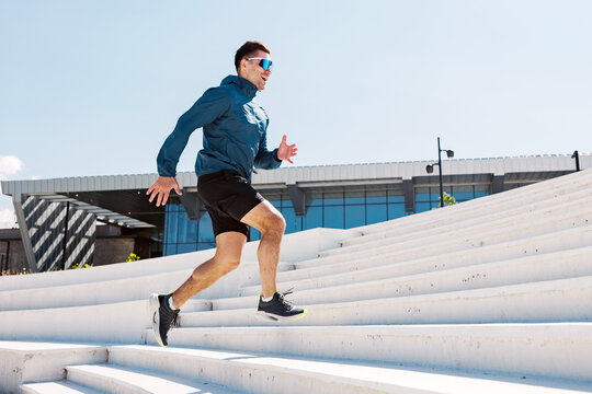 Running up the stairs in a bright, sunny urban setting