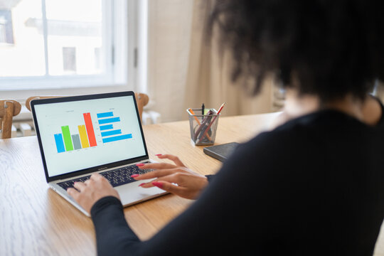 Working on data analysis with colorful charts and graphs in a cozy room