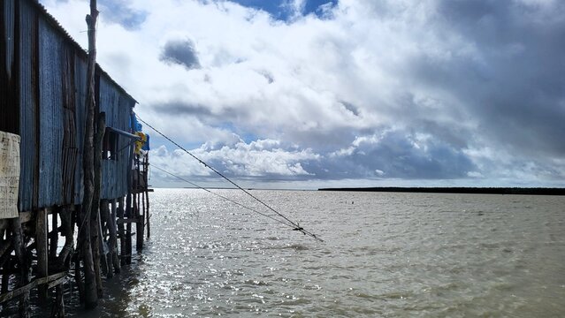 Weathered corrugated-metal huts stand on narrow wooden stilts 