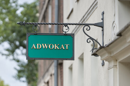 gr&uuml;nes Schild mit dem polnischen Wort Adwokat, Anwalt in der Innenstadt von Danzig, Gdansk in Polen