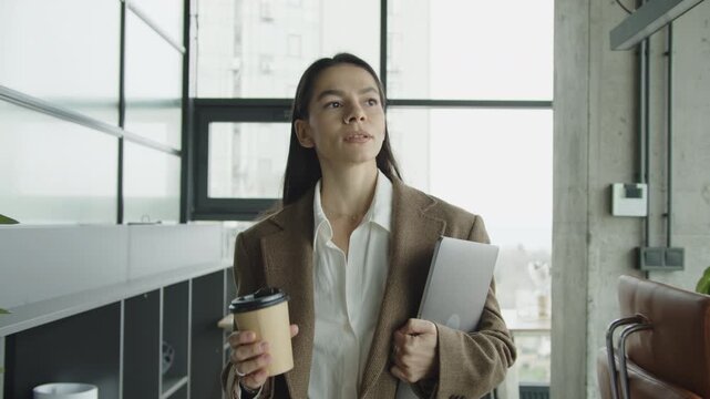 Coffee break. Businesswoman walk in office. Business woman at coffee break. Businesswoman walking with laptop. CEO having free time. Business break. Millennial businesswoman drinking coffee