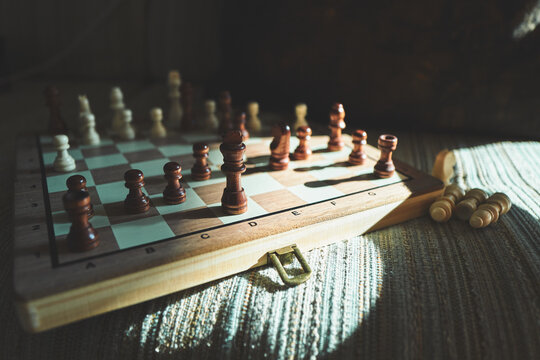 Wooden Chess Set Mid-Game with Captured Pieces Beside the Board