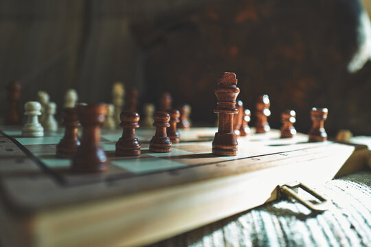 Close-Up of Wooden Chess Pieces on a Board in Moody Light