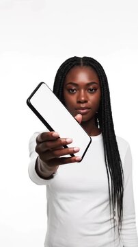 Black woman showing blank smartphone screen on white