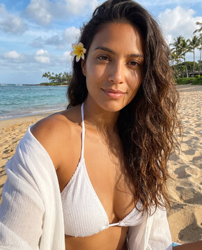 woman modeling on a sunny beach, she is poised in swimwear