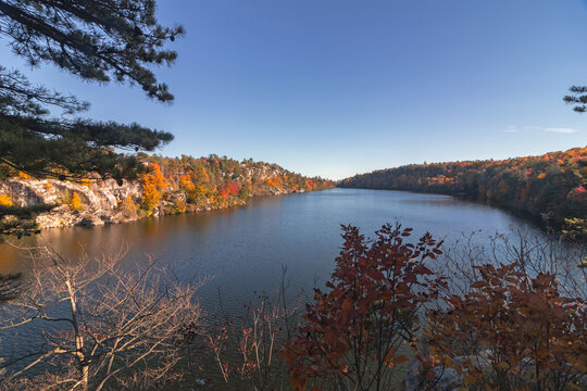 Lake Minnewaska in Minnewaska State Park, NY, on a crisp and clear Autumn morning surrounded by vivid fall foliage