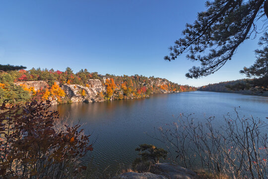 Lake Minnewaska in Minnewaska State Park, NY, on a crisp and clear Autumn morning surrounded by vivid fall foliage