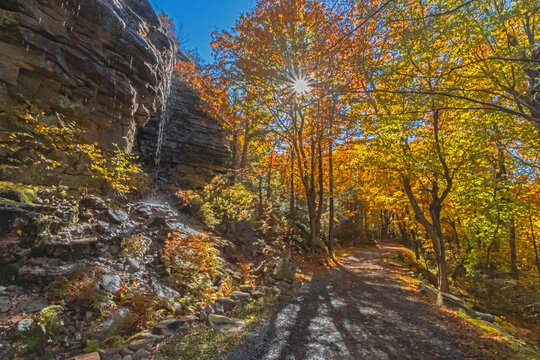 Upper Awosting carriage road  in Minnewaska State Park, NY, on a crisp and clear Autumn morning surrounded by vivid fall foliage