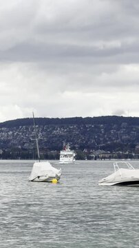 Boats and passenger ferry on Lake Zurich under cloudy sky