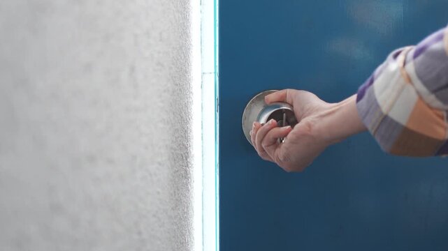 Hand Opening Blue Door by Turning Doorknob, Slow Motion