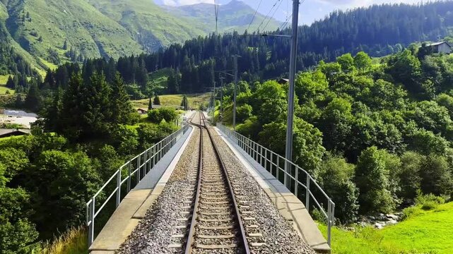 Rear View From the Glacier Express Train on Railroad Tracks with Mountainscape and Valley in a Sunny Summer Day in Sedrun, Surselva, Oberalp, Grisons, Switzerland