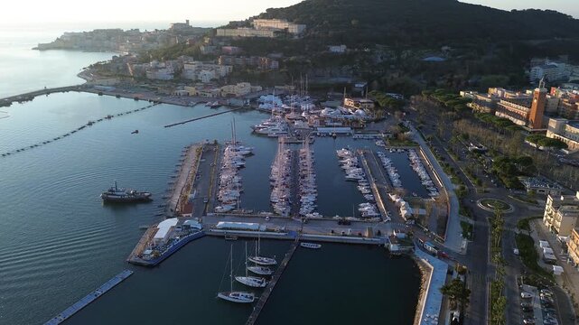 Aerial perspective of a coastal city with a harbor, boats docked, and surrounding mountains, Gaeta, Italy