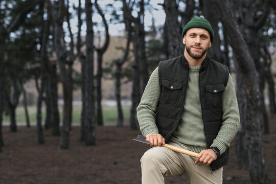 Sustainable forestry and outdoor lifestyle, man with axe in forest representing woodcraft, survival skills, and connection to nature in autumn woods