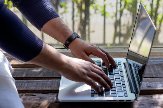 Horizontal stock photo of person typing on a laptop computer on a rustic wooden table