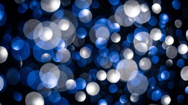Blue white bokeh light abstract background with glowing circles and soft focus effect in dark space