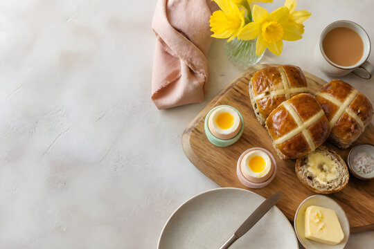 Easter brunch with hot cross buns soft boiled eggs and daffodils