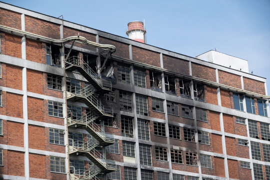A prefabricated apartment building with a charred facade and broken windows.