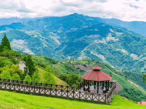 Wooden gazebo and observation deck overlooking green mountain terraces