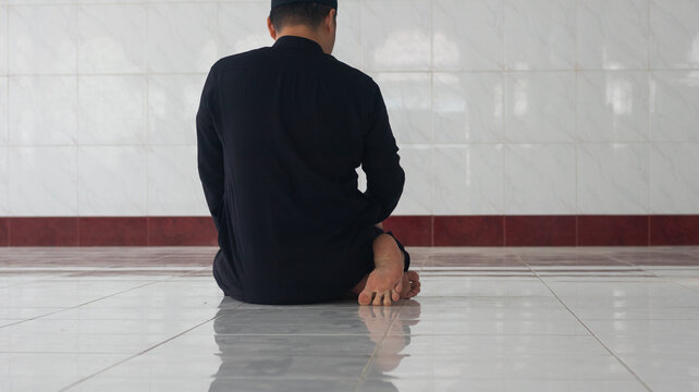 Man Praying in Salah Position on Tiled Floor