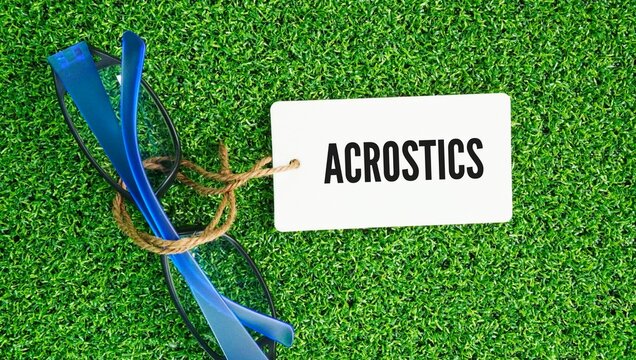 Glasses and paper tags with the word acrostic is a poem, text, or word composition where the first letter, syllable, or word of each line spells out a hidden word, name, or message when read verticall