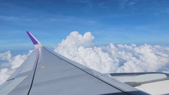Beautiful window view while traveling by an airplane above the clouds.