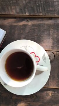 Vertical 4K video sequence of finance notebook and coffee on wooden table