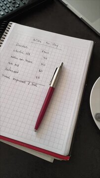 Vertical video sequence of workspace desk with finance notebook and coffee