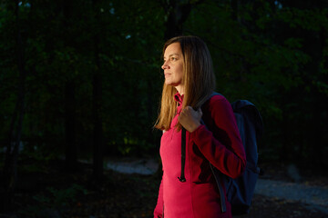 Woman in fleece jacket with hiking backpack standing in forest © Lazy_Bear
