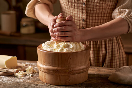Hands churning butter in a rustic kitchen