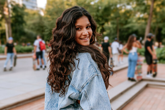 Indian girl wearing washed denim jacket, smiling with 90s grunge style fashion