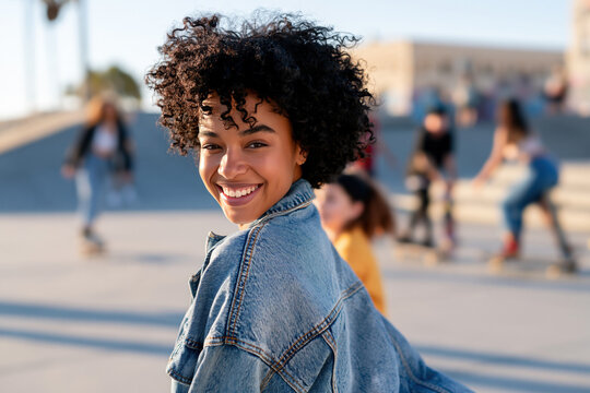 Afro girl wearing washed denim jacket, smiling with 90s grunge style fashion