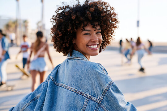 Afro girl wearing washed denim jacket, smiling with 90s grunge style fashion