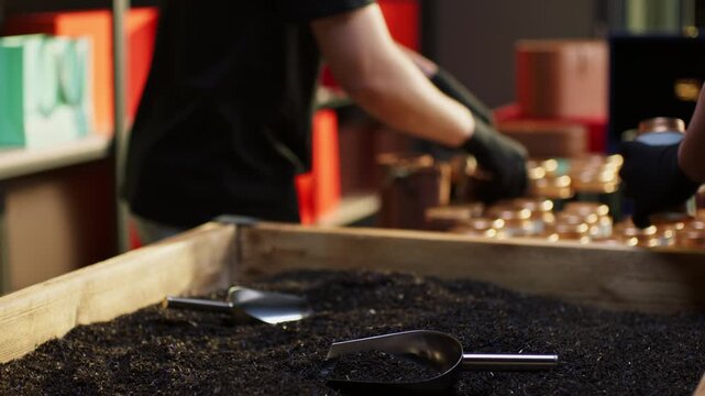 Close-up of pouring tea from containers at factory