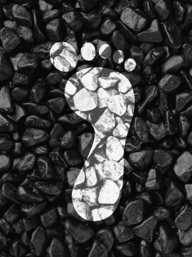 Carbon footprint impression on dark pebbles environment