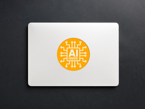 Laptop computer displaying artificial intelligence concept sticker