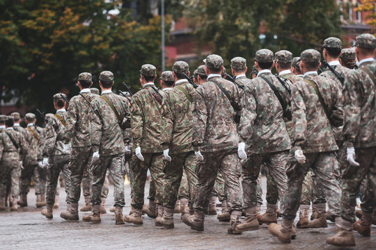 Romanian army soldiers march during a military ceremony on a rainy day