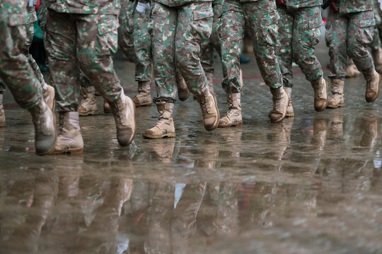 Romanian army soldiers march during a military ceremony on a rainy day