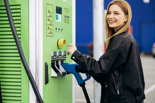 Happy woman selecting payment option on an ev charging station, promoting eco-friendly transportation and green technology