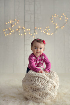 Adorable baby girl smiling with heart shaped lights