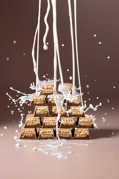 Milk splashing over a pyramid of wafer chocolate bars