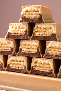 Geometric stack of chocolate wafer cubes on warm studio background
