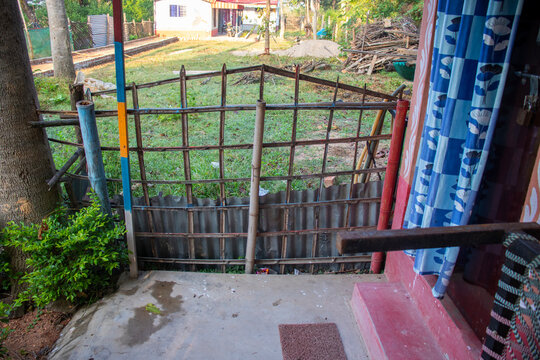 A rustic bamboo barrier adds natural charm, privacy, and traditional character to a cozy cottage surrounded by peaceful countryside greenery.