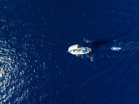 Aerial view of sailboat in the deep blue sea in Sardinia, Italy