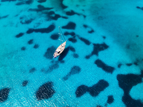 Aerial view of yachts anchored in turquoise water at Brandinchi beach, Sardinia