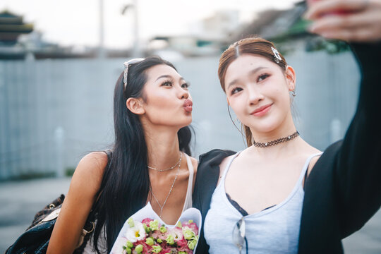 Two young women authentic Gen Z selfie for social media shared experience moment in Asia local travel