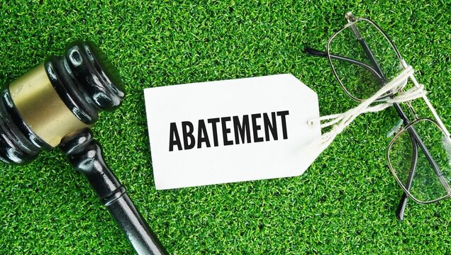 Judge's gavel and paper tags with the words Abatement means a reduction, decrease, lessening, or suppression of an amount, intensity, or legal claim.