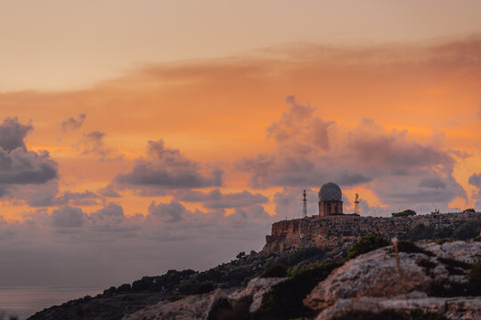 Sunset Landscape, Iconic Radar Station Dome Against Pastel Orange Sky, Limestone Coastline of Dingli Cliffs, Malta