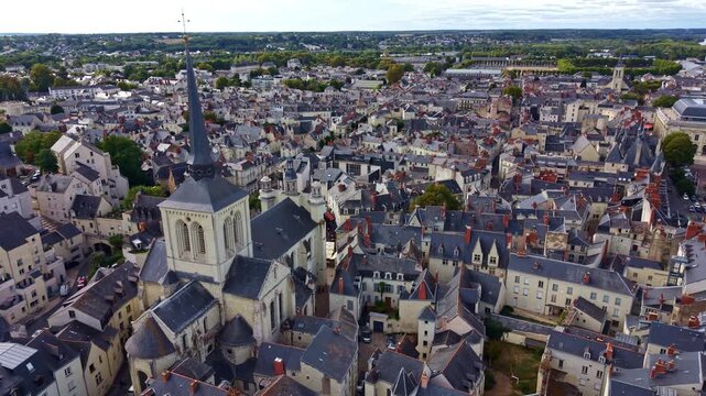 Backward drone movement from Romanesque Church of Saint-Pierre-du-Marais or simple Saint-Pierre church revealing dense Saumur town, France