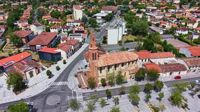 Drone orbit over the neo-Gothic Saint-Joseph Church or Eglise Saint-Joseph with a brick bell tower in Balma district of Toulouse, France